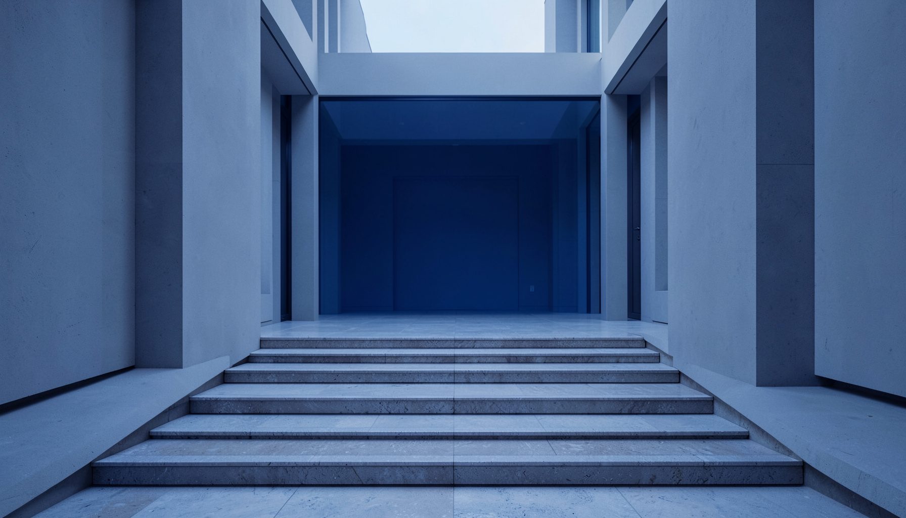 Symmetrical rows of polished stone steps leading to a quiet public courtyard in soft gray and muted blue light